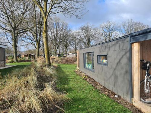 a small house with a window on the side of it at Chalet Panorama near Efteling - with garden and swimmingpool Europarcs in Kaatsheuvel