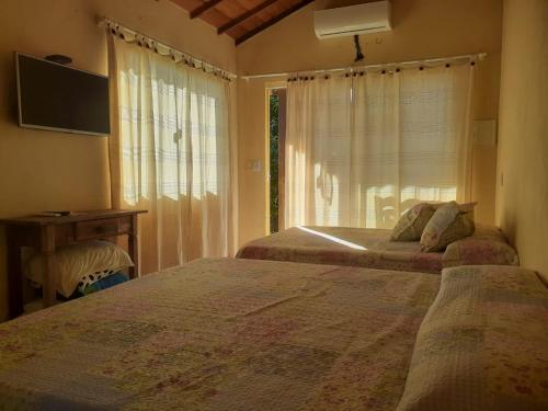 a bedroom with two beds and a window at Pousada Alto da Marina in Búzios