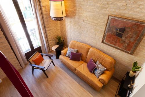een woonkamer met een bank bij Duplex en el casco antiguo de Sevilla in Sevilla