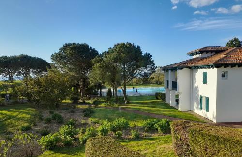une maison avec un jardin à côté de l'eau dans l'établissement Atlantic Selection - Domaine de Bordaberry - Avec piscine et vue océan, à Urrugne