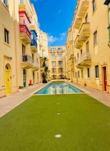 a swimming pool in the middle of a building at New, Modern Ground Floor Apartment with Pool in Għajnsielem
