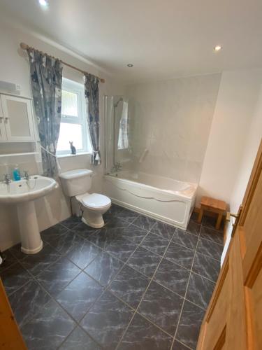 a bathroom with a tub and a toilet and a sink at Beachview Cottage Co. Antrim in Cushendun