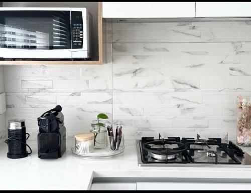 a kitchen counter with a stove and a microwave at Trafalgar Place in Auckland