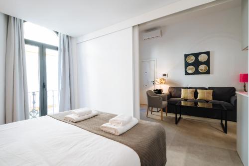 a bedroom with a bed and a living room at apartamentos montevideo 6 in Seville