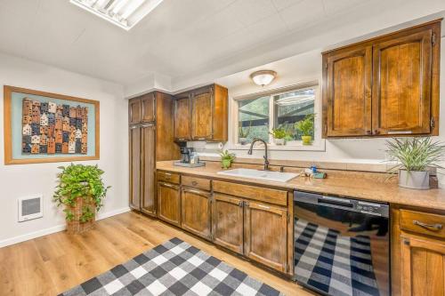 eine Küche mit Holzschränken und einer Spüle in der Unterkunft Bright, Updated Waterfront Cottage Pets Welcome! in Longview