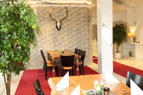 a dining room with a table and a antlers on the wall at Lobinger Hotel Weisses Ross in Langenau