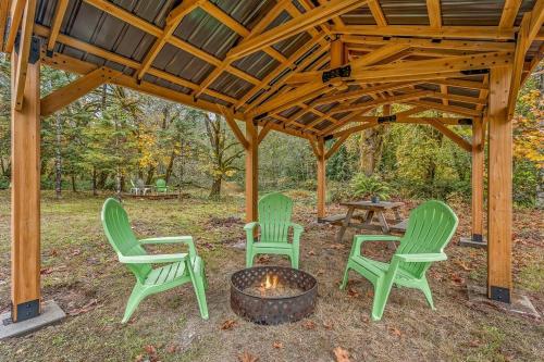 drei grüne Stühle und eine Feuerstelle unter einem Pavillon in der Unterkunft Bright, Updated Waterfront Cottage Pets Welcome! in Longview