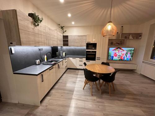 a kitchen with a table and a tv in it at Lovely 2-bedroom apartment in centre of Bratislava in Bratislava