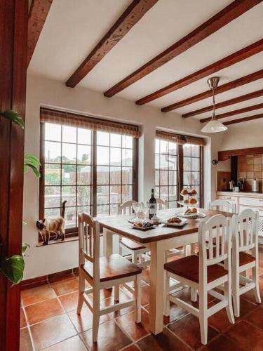 a kitchen with a table and a dog looking out the window at Casa La Encarnación in Santa Cruz de la Palma