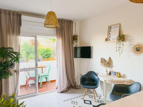 - un salon avec une table et des chaises ainsi qu'une salle à manger dans l'établissement Apartamento moderno y acogedor cerca del mar, à Fuengirola