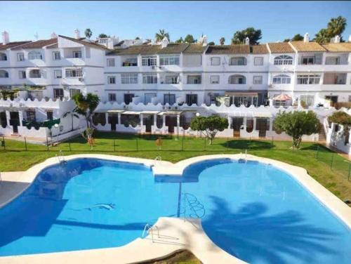 une grande piscine en face d'un grand bâtiment dans l'établissement Apartamento moderno y acogedor cerca del mar, à Fuengirola