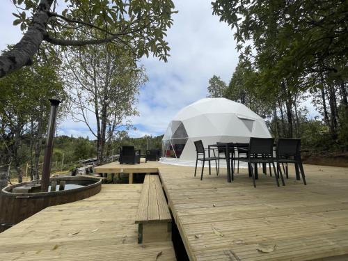 an igloo house with a table and chairs on a wooden deck at Lodge Los Alerces in Los Muermos