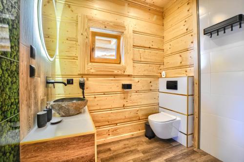a wooden bathroom with a sink and a toilet at Santa Angela Solina Centrum - Zapora in Solina