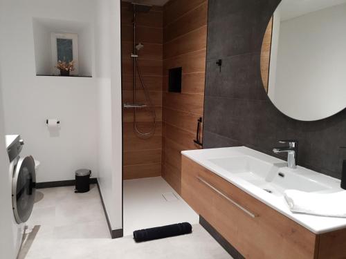 W łazience znajduje się umywalka i prysznic. w obiekcie Ô Valanvron - Appartement dans une ancienne ferme neuchâteloise w mieście La Chaux-de-Fonds