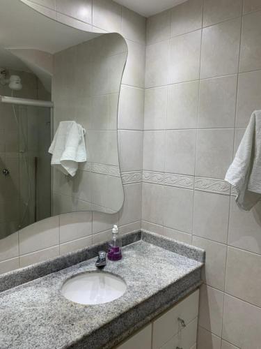 a bathroom with a sink and a mirror at Porto Marina in Salvador
