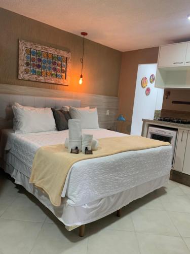 a bedroom with a large bed with towels on it at Pousada Reserva Penedo in Penedo