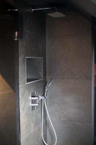 a shower in a bathroom with a shower head at Sellmann´s Boutique Hotel in Dortmund