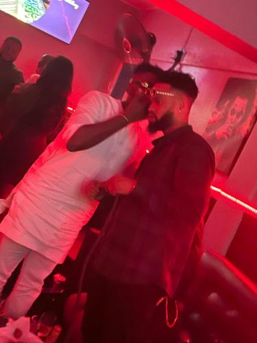 two men dancing in a club with red lights at Suite Subzero in Lagos