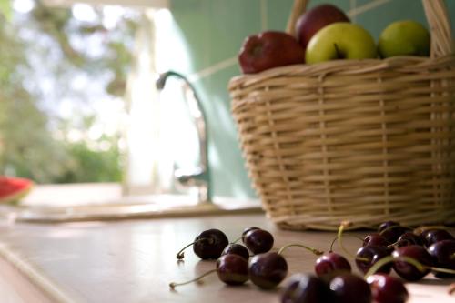 a bunch of cherries sitting on a counter with a basket of apples at Isalos in Vasiliki