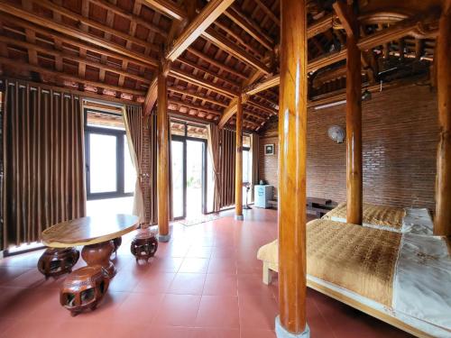a bedroom with a bed and a table in a room at T'Farmstay villa and resort Buon Ma Thuot City in Buon Ma Thuot