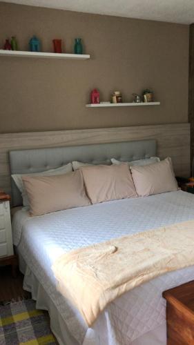 a bed with white sheets and pillows in a bedroom at Pousada Reserva Penedo in Penedo