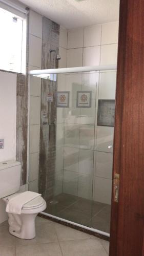 a bathroom with a shower and a toilet at Pousada Reserva Penedo in Penedo