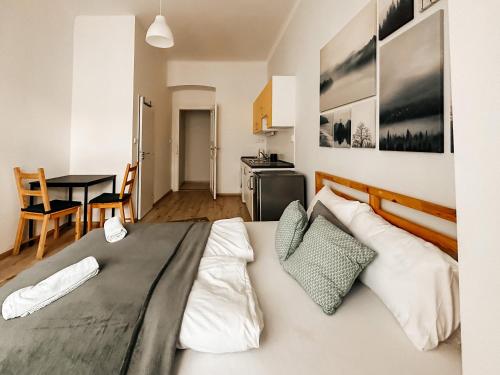 a bedroom with a large bed and a table at Savor Apartment in Prague