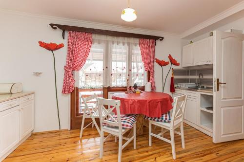eine Küche mit einem roten Tisch und Stühlen sowie einem Fenster in der Unterkunft Holiday Home Captain's Village in Šljivovica