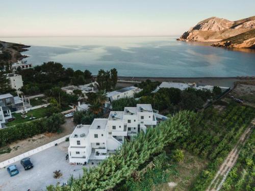 eine Luftansicht eines weißen Gebäudes neben dem Wasser in der Unterkunft SKYROS BLUE SUITES in Skyros