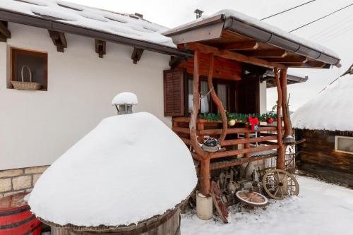 a snow covered house with a snow covered roof at Holiday Home Captain's Village in Šljivovica