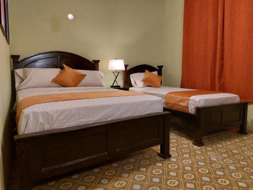 a bedroom with two beds and a lamp at Hospedaje Los Lirios Chitré in Chitré