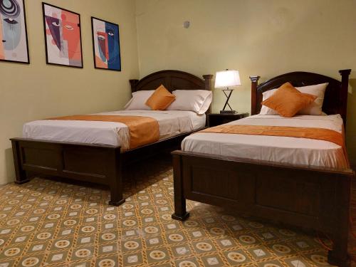 two beds in a hotel room with two at Hospedaje Los Lirios Chitré in Chitré