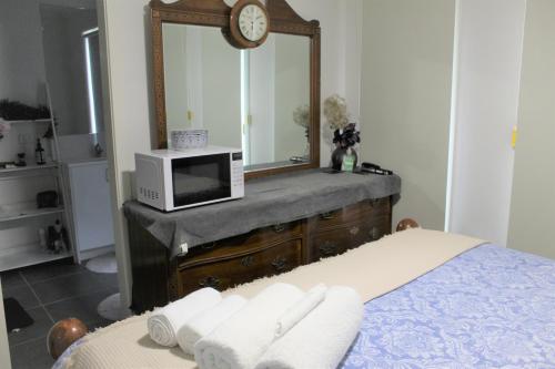 a bedroom with a microwave and a bed with towels at Room in Officer in Officer
