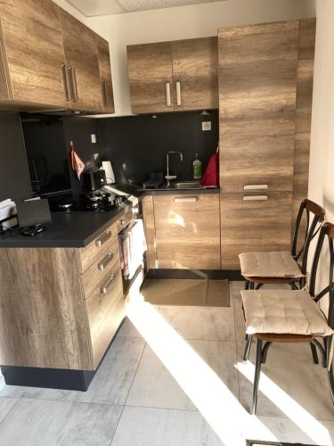 une cuisine avec des armoires en bois et une table et des chaises dans l'établissement Domaine Nature Vacances, à Bernécourt