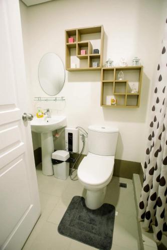 a bathroom with a white toilet and a sink at JHS condotel in Roxas City