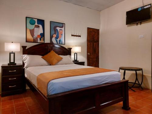 a bedroom with a bed and a flat screen tv at Hospedaje Los Lirios Chitré in Chitré