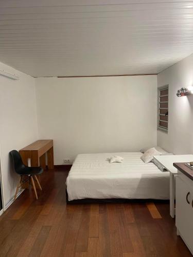 1 dormitorio con cama, escritorio y silla en Bourail take rest en Bourail