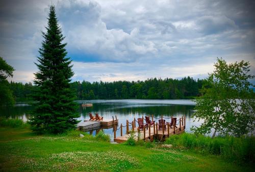 a dock on a lake with chairs on it at Domaine Gagnon in Saint Sebastien