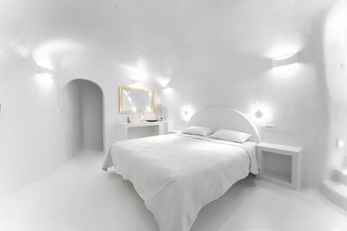 Dormitorio blanco con cama blanca y paredes blancas en Sun Naam Home Santorini with heated jacuzzi en Karterados