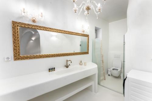 a bathroom with a white sink and a mirror at Sun Naam Home Santorini with heated jacuzzi in Karterados