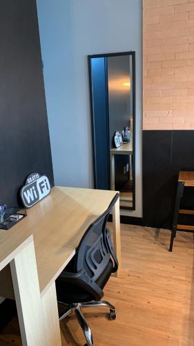 an office with a desk with a chair and a mirror at Modernidade e conforto para sua hospedagem !!! in Sao Paulo