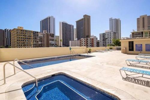 una piscina en la parte superior de un edificio con ciudad en Make your Waikiki Beach Stay Unforgettable en Honolulu