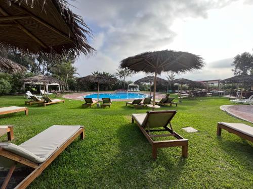 een park met ligstoelen en een zwembad bij Bungalows de Casa Verde in Mala
