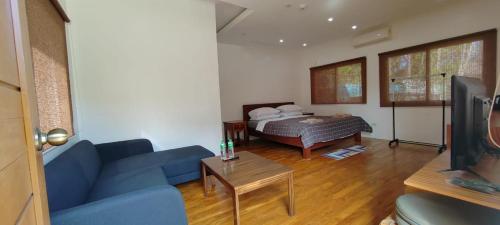 a living room with a blue couch and a bed at Nahas Beach Resort in Abung