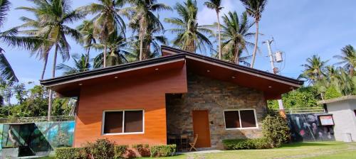 a small house with palm trees in the background at Nahas Beach Resort in Abung