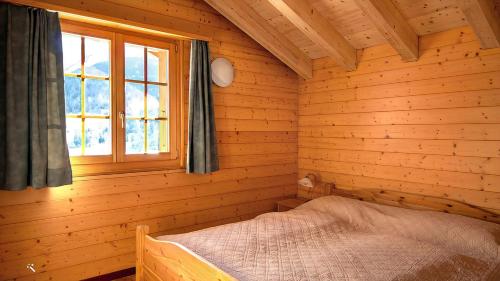 sypialnia z łóżkiem w drewnianym domku w obiekcie Cresta w mieście Fiesch