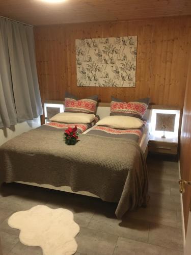 ein Schlafzimmer mit einem großen Bett mit roten Kissen in der Unterkunft Kranich-Holzferienhaus 'Kleine Auszeit' in Rehden