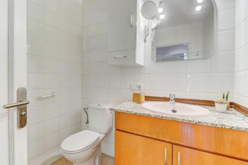 ein weißes Bad mit einem WC und einem Waschbecken in der Unterkunft Villa Es Torrent by Villa Plus in Port d'Alcúdia