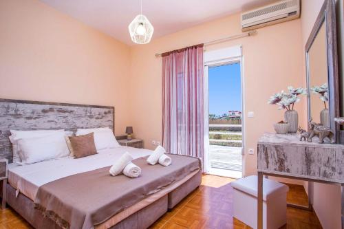 a bedroom with a large bed and a large window at Villa Kalathos by Villa Plus in Kalathos