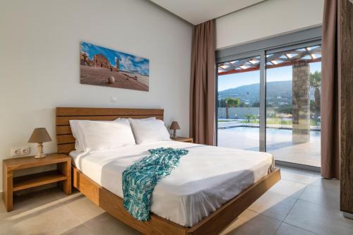 Villa Elite Kalathos by Villa Plus في كالاثوس: غرفة نوم بسرير ونافذة كبيرة